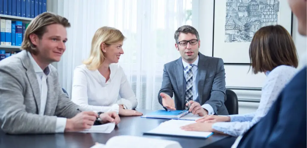 Rechtsanwälte und Notare an einem Schreibtisch bei einer Besprechung